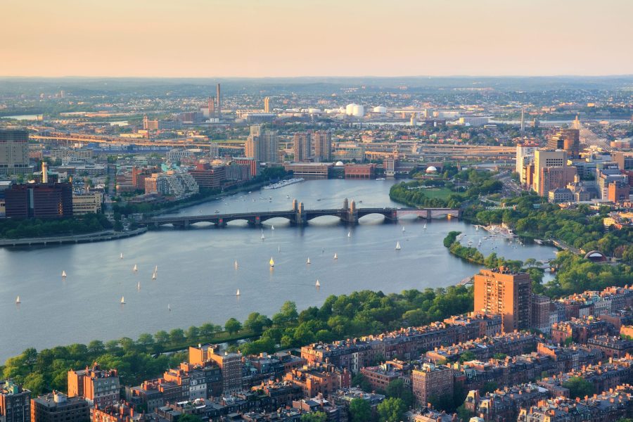 Boston Charles River sunset aerial view with urban buildings and bridge.