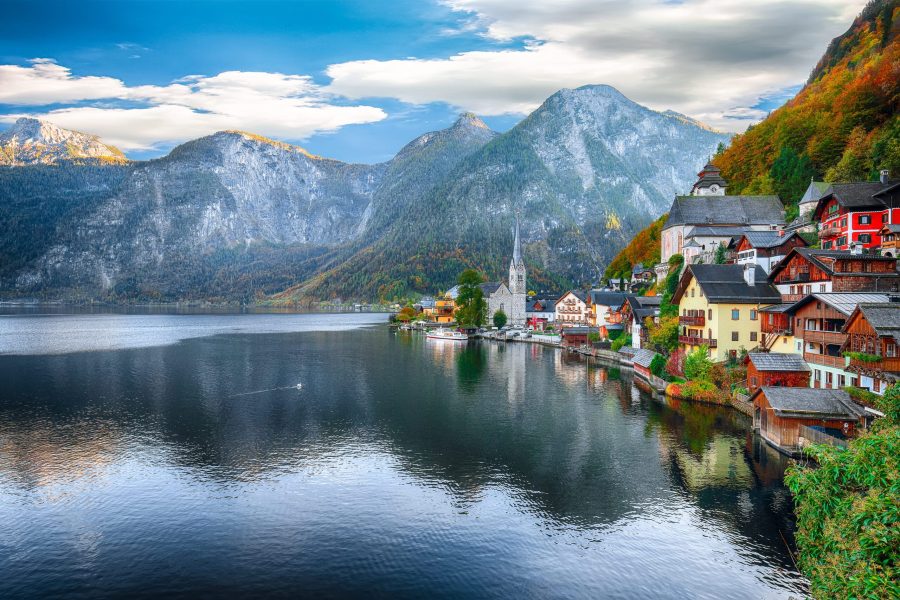 Scenic view of famous Hallstatt mountain village with Hallstatter lake. Sunny autumn sunrise on Hallstatt lake. Location: resort village Hallstatt, Salzkammergut region, Austria, Alps. Europe.